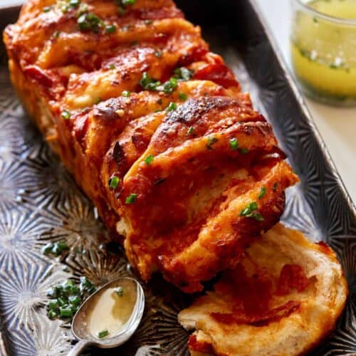 Pizza pull apart bread with a spoon and garlic herb butter.