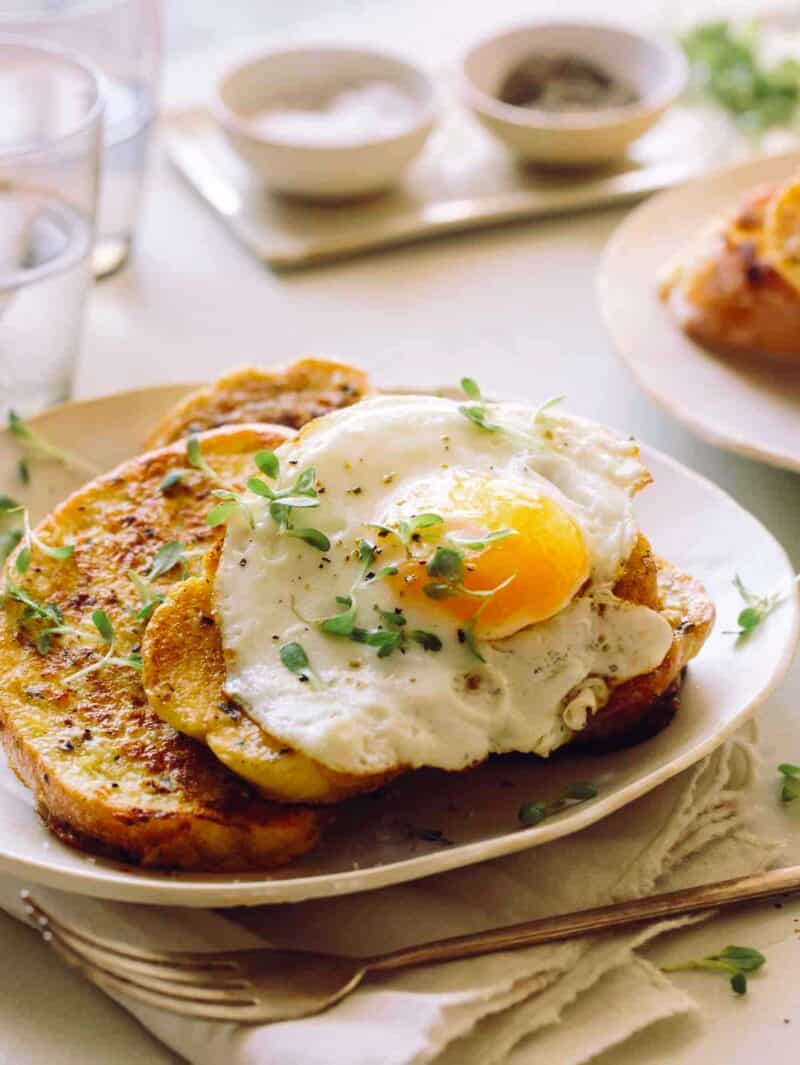 Savory Herb French Toast with a fried egg on top and some micro herbs. 