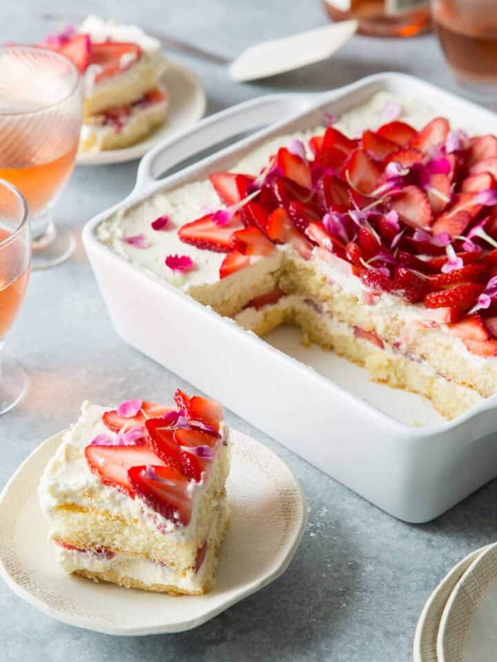 A sliced strawberry tiramisu with a piece on a small plate, a Valentines day dessert. 