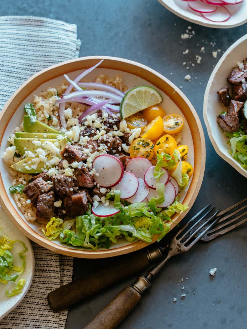 Carne asada burrito bowls with forks.