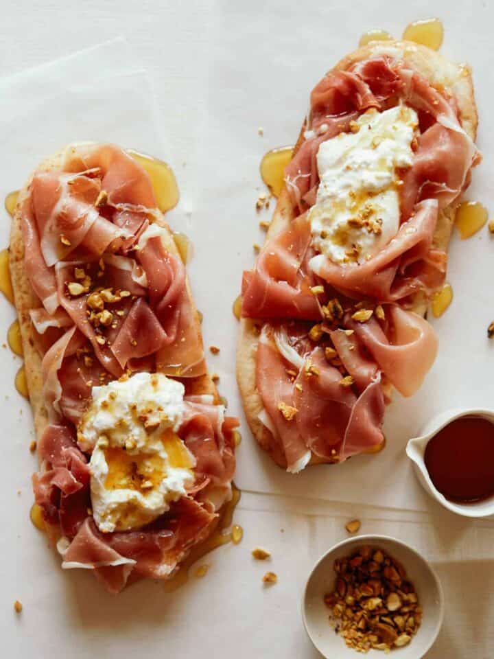 Simple charcuterie flatbreads with honey on the side.