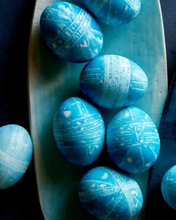 Blue DIY shibori style easter eggs on a blue plate.