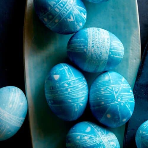 Blue DIY shibori style easter eggs on a blue plate.