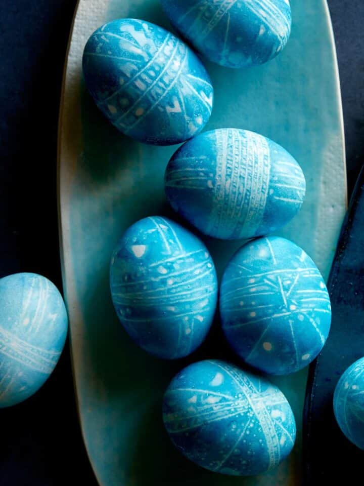 Blue DIY shibori style easter eggs on a blue plate.