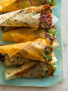 Stacked spicy marinated pork belly hand rolls.