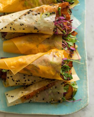 Stacked spicy marinated pork belly hand rolls.