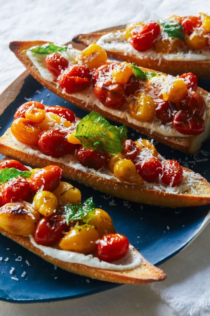 A close up of roasted cherry tomato and whipped feta toast.