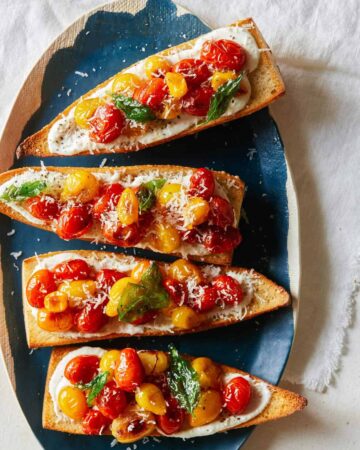 A platter of roasted cherry tomato and whipped feta toast.