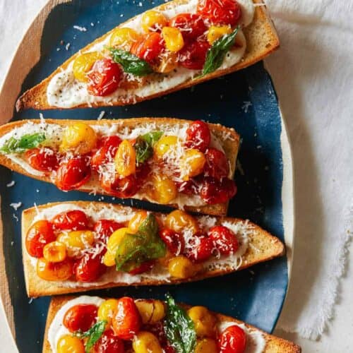 A platter of roasted cherry tomato and whipped feta toast.