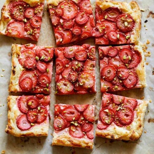 Strawberry Tart with pistachios on a parchment sheet.