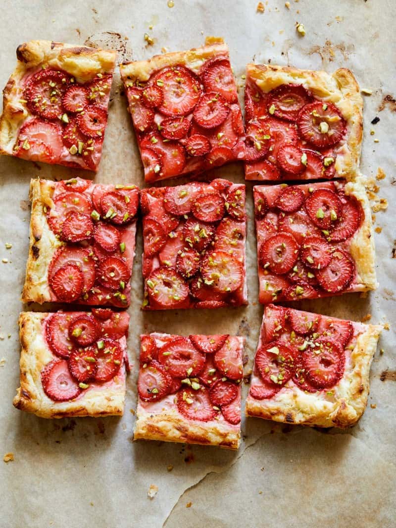 Strawberry Tart with pistachios on a parchment sheet.