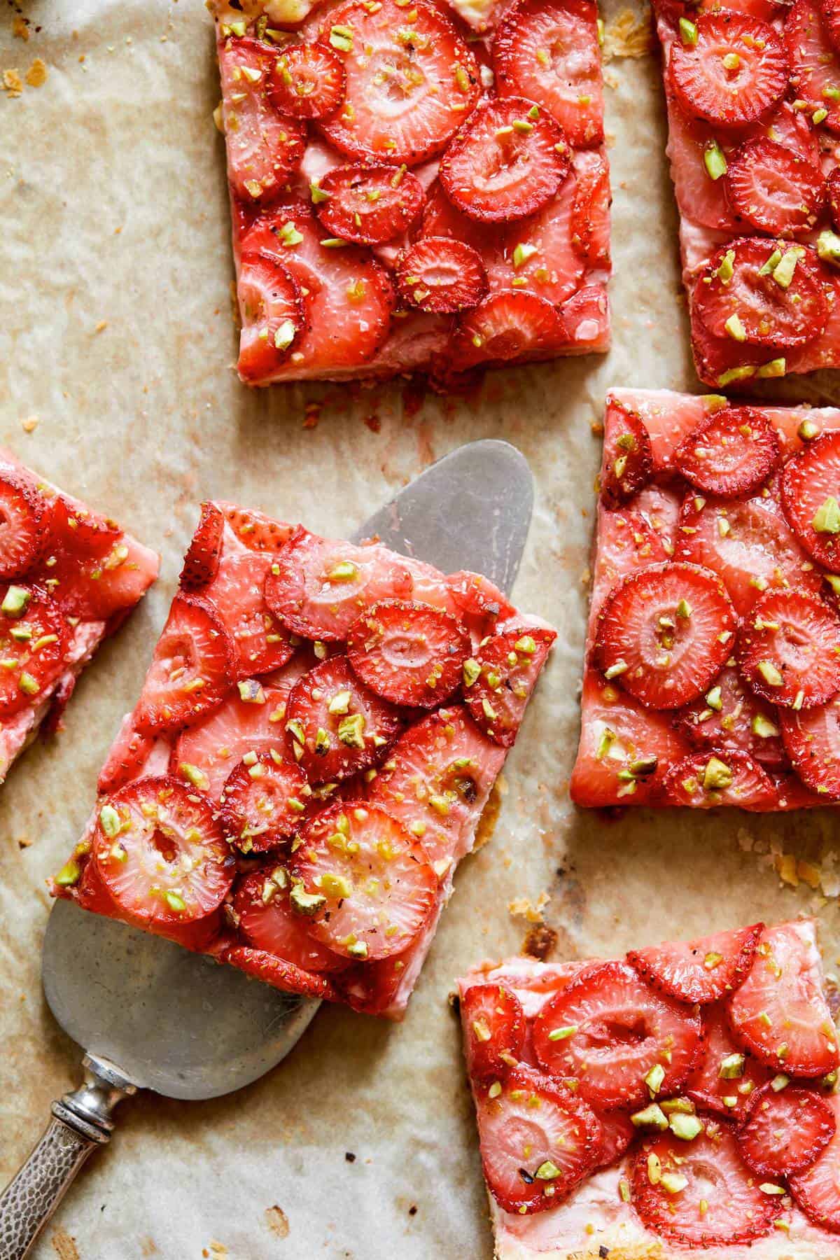 Strawberry Tart cut up with a a serving utensil. 