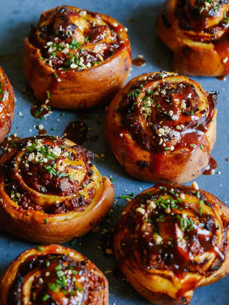 BBQ Pulled Pork rolls topped with tangy BBQ sauce, sliced chives and nuts. 