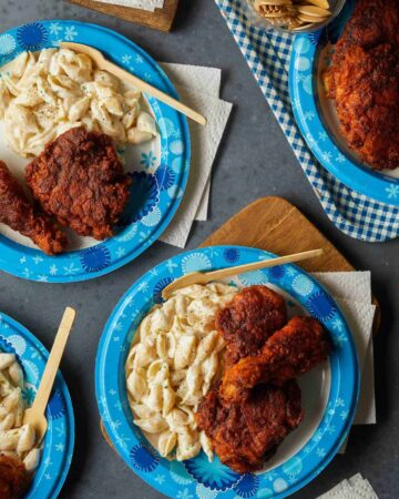 Dixie paper plates of Nashville hot chicken with mac and cheese and disposable wood forks.