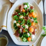 Fresh summer appetizer platter with napkins and a drink.