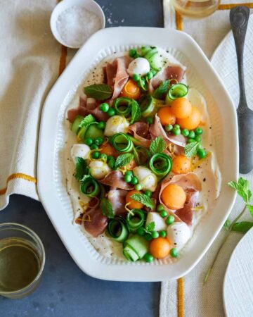 Fresh summer appetizer platter with napkins and a drink.
