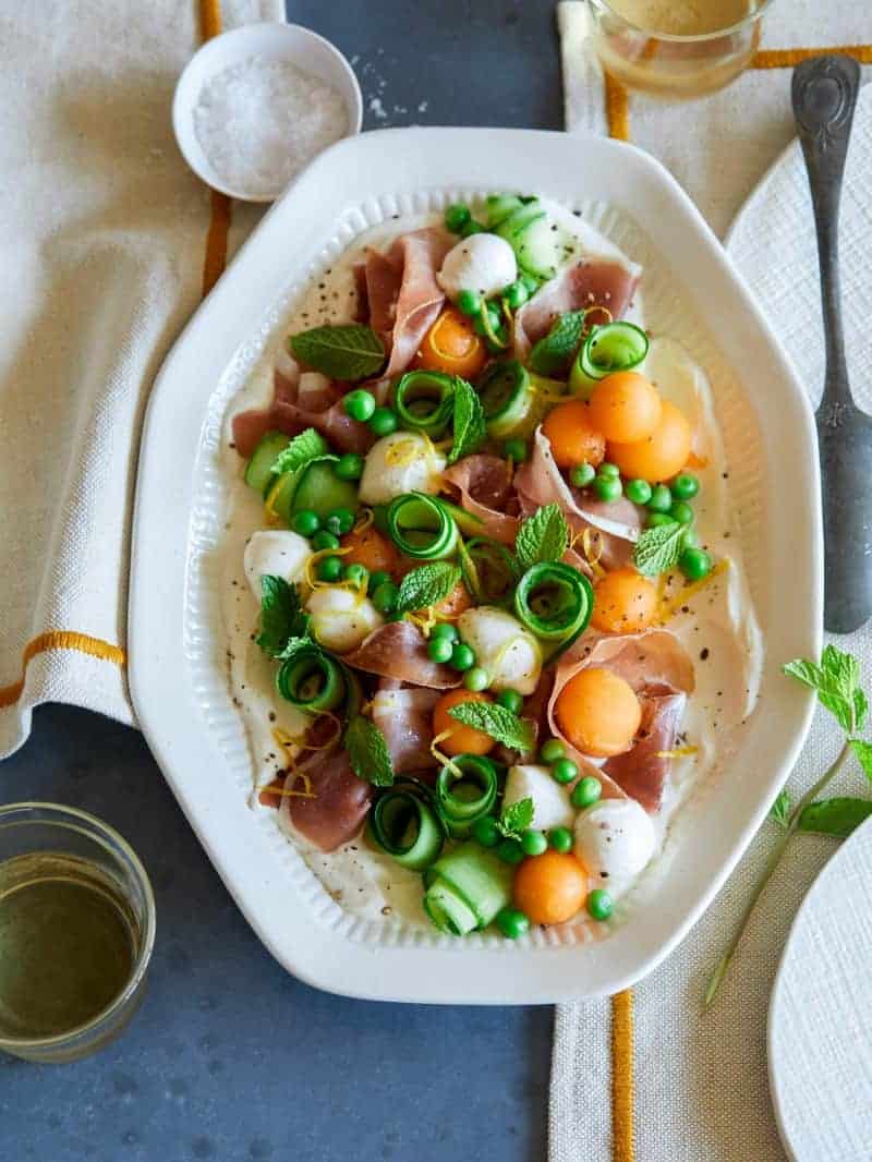 Fresh summer appetizer platter with napkins and a drink.