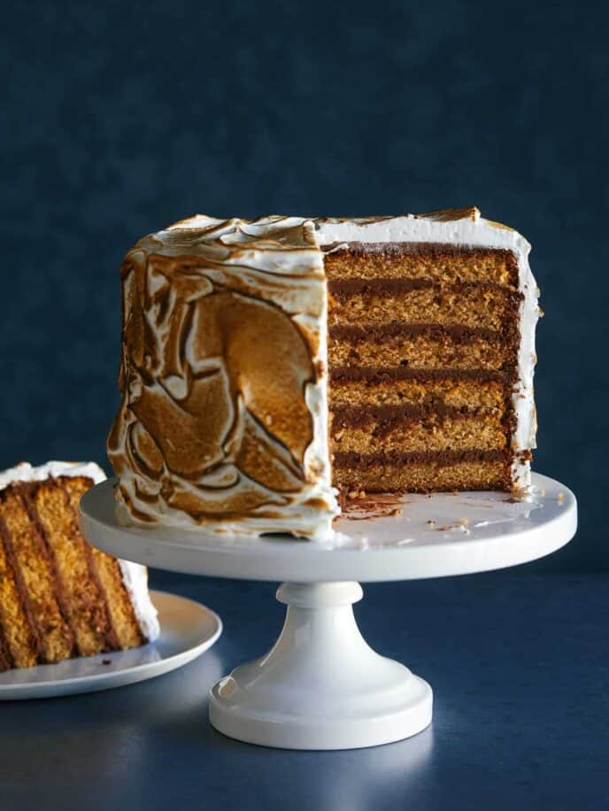 A six layer s'mores cake with a slice cut out and served on a plate.