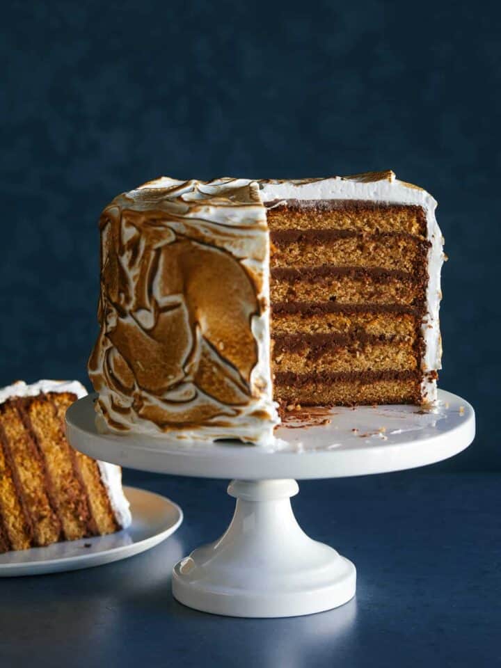 A six layer s'mores cake with a slice cut out and served on a plate.