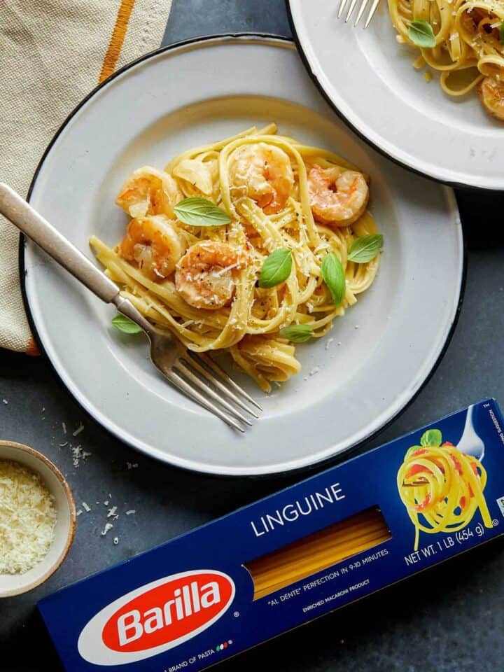 A plate of shrimp linguine with cream sauce next to a box of Barilla linguine.