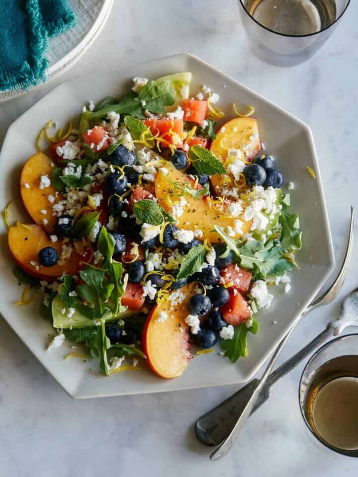 A plate of end of summer fruit salad with forks.