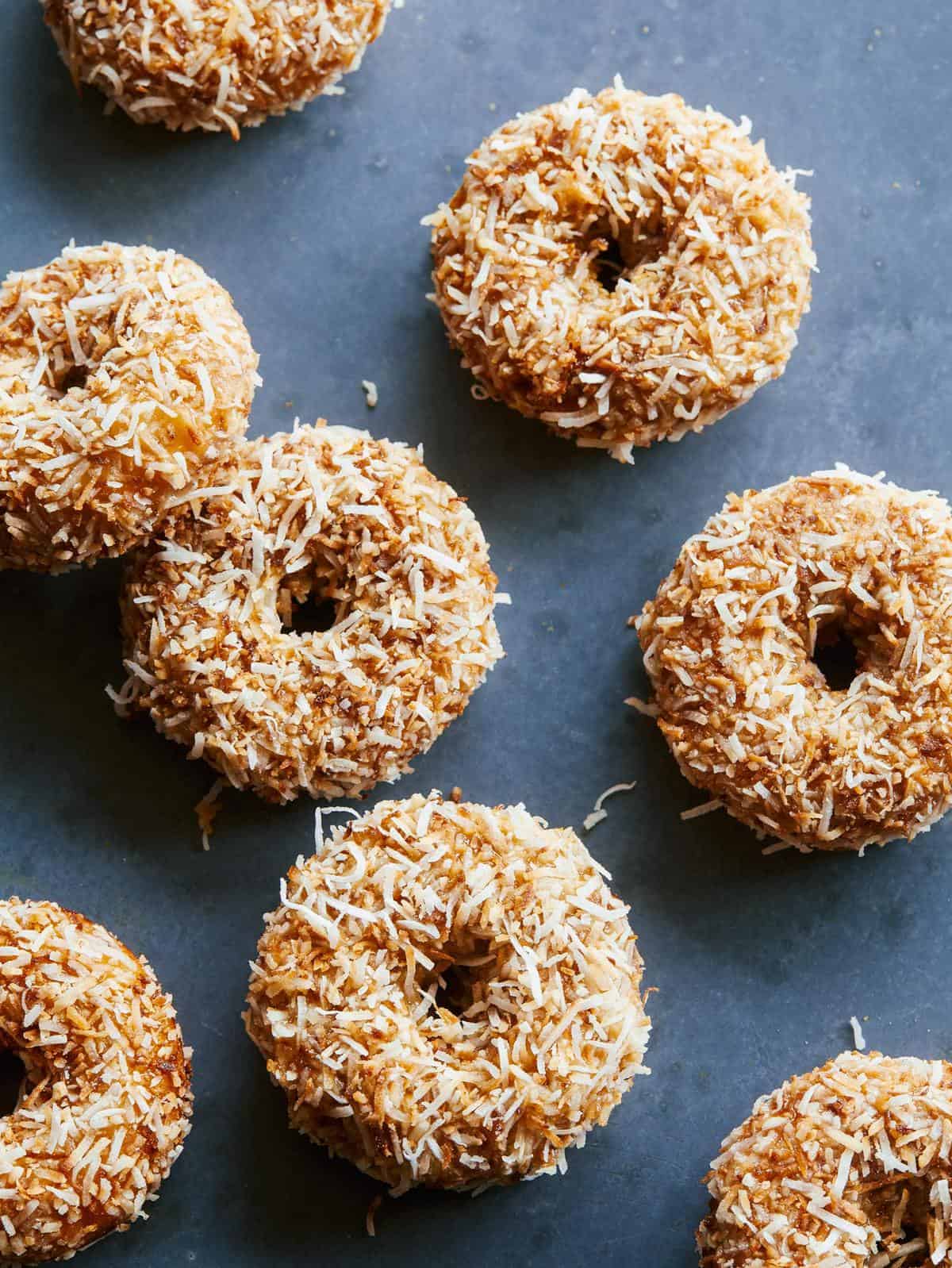 Baked pumpkin cake doughnuts with maple glaze and toasted coconut.