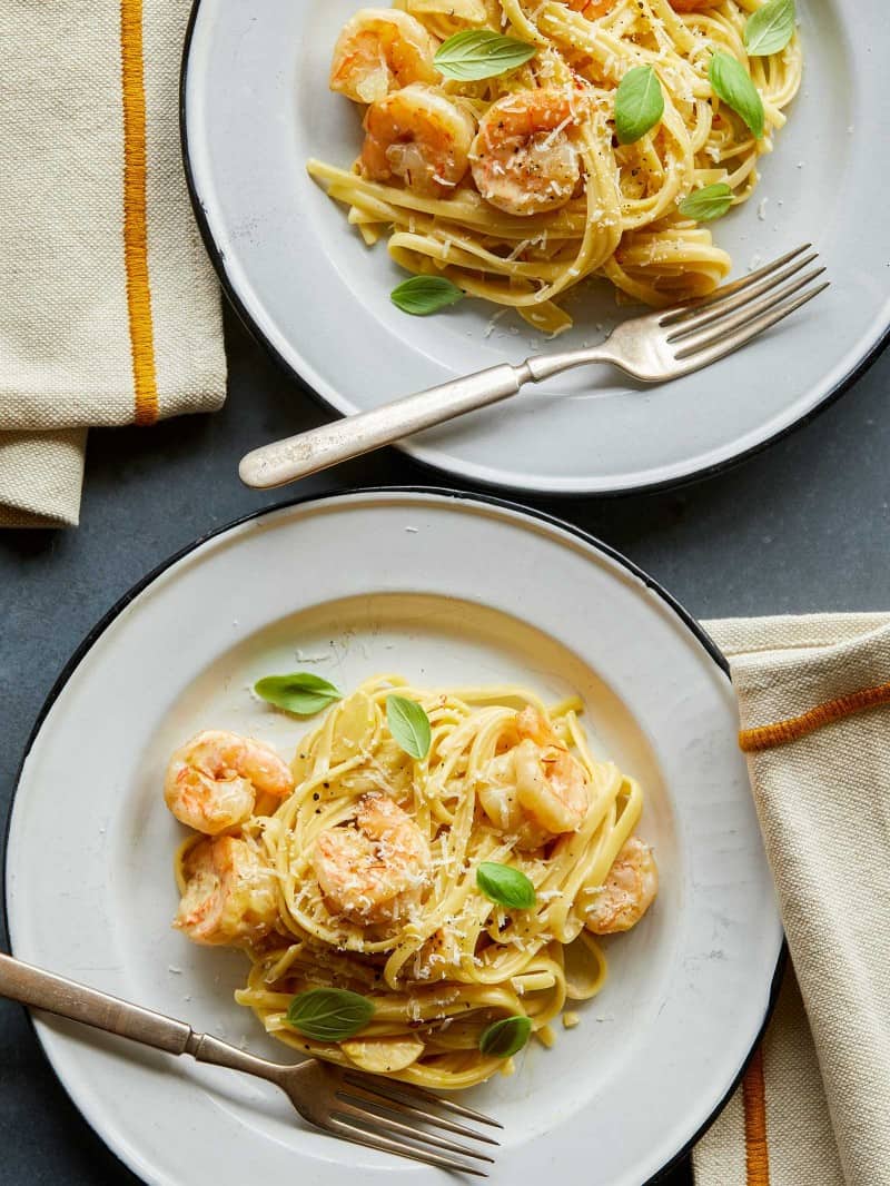 Shrimp Linguine on two plates with forks and napkins.