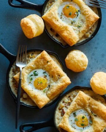 Breakfast pot pies in individual skillets with a fork.