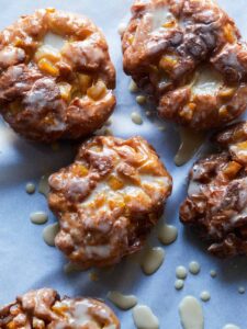A close up of apple fritters with maple glaze.