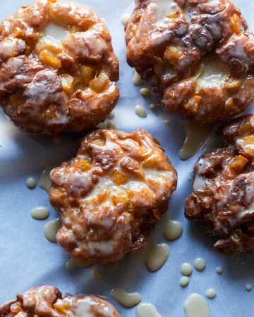 A close up of apple fritters with maple glaze.
