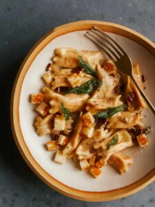 Creamy sweet potato agnolotti on a plate with a fork.