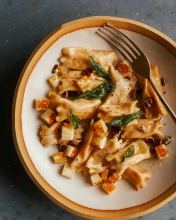 Creamy sweet potato agnolotti on a plate with a fork.