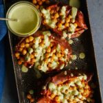 Roasted chickpea stuffed sweet potatoes with cilantro garlic cashew sauce on the side.