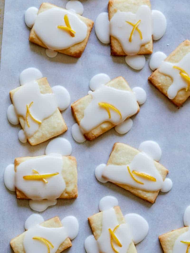 Meyer Lemon Meltaways on a baking sheet freshly glazed with frosting. 