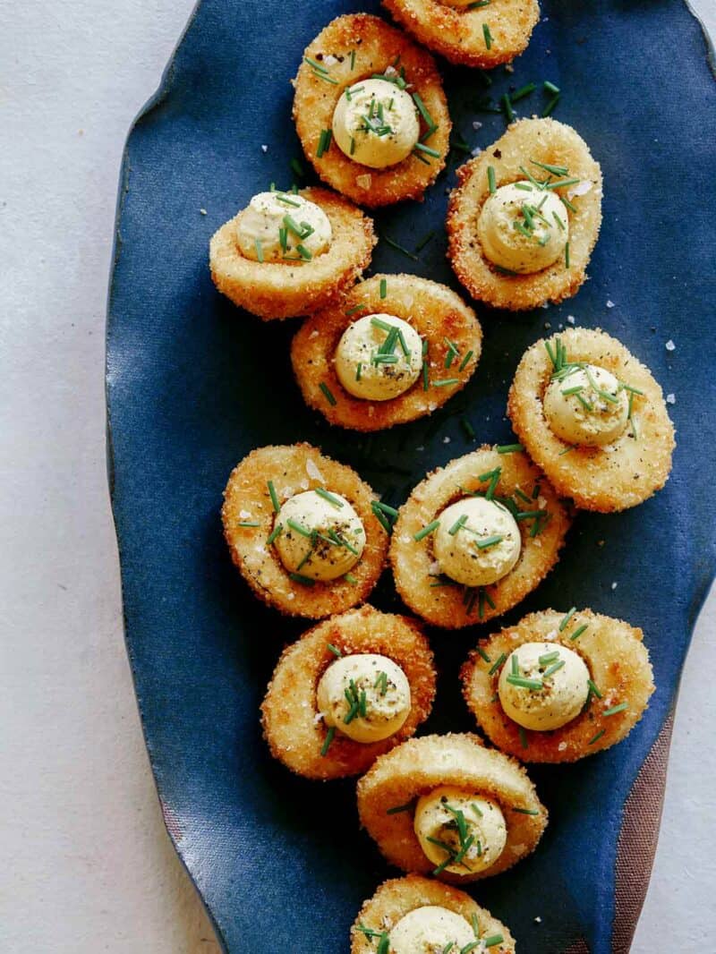 Fried deviled eggs on a blue platter.