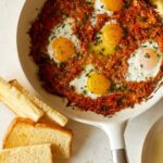 Cheesy skillet sweet potato hash browns and eggs with toast.