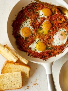 Cheesy skillet sweet potato hash browns and eggs with toast.