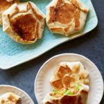 A platter of mini crunchwrap supremes and served on a small plate.