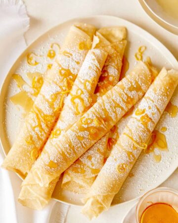 Meyer lemon and ricotta stuffed crepes on a plate.