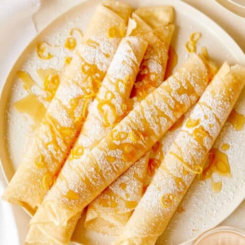 Meyer lemon and ricotta stuffed crepes on a plate.