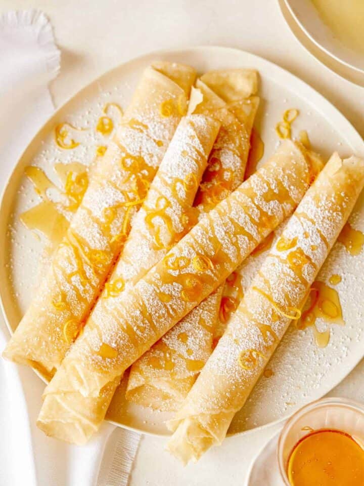 Meyer lemon and ricotta stuffed crepes on a plate.