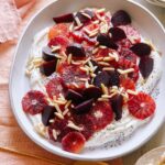 Blood orange and beet salad over honeyed yogurt in a bowl.