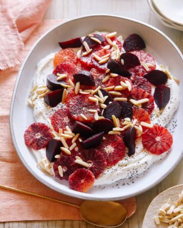 Blood orange and beet salad over honeyed yogurt in a bowl.