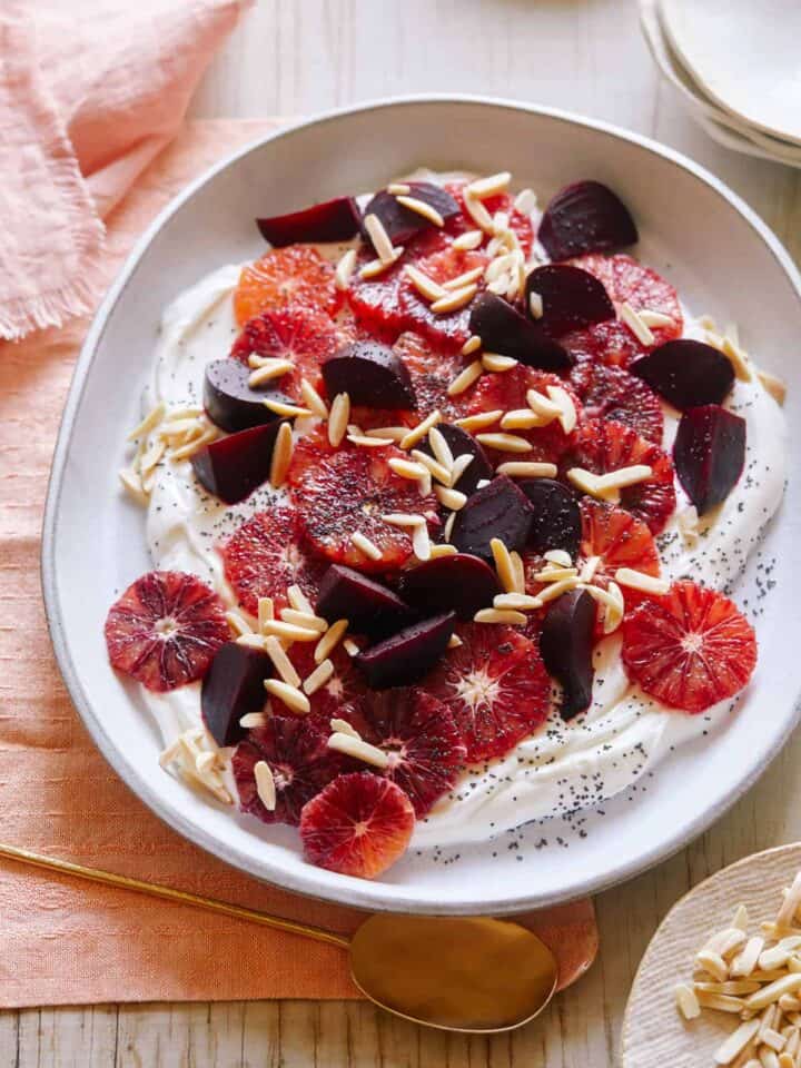 Blood orange and beet salad over honeyed yogurt in a bowl.