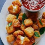 A close up of hallumi nuggets with marinara sauce on the side. A recipe to make as New Years Eve finger foods.