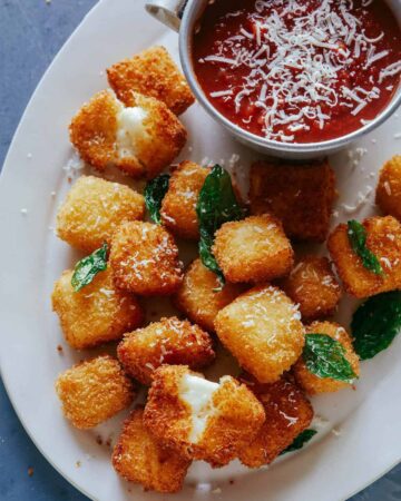 A close up of hallumi nuggets with marinara sauce on the side. A recipe to make as New Years Eve finger foods.