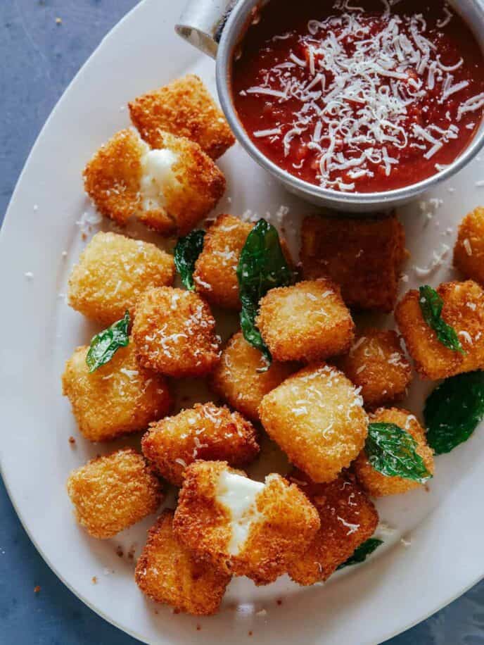 A close up of hallumi nuggets with marinara sauce on the side. A recipe to make as New Years Eve finger foods. 