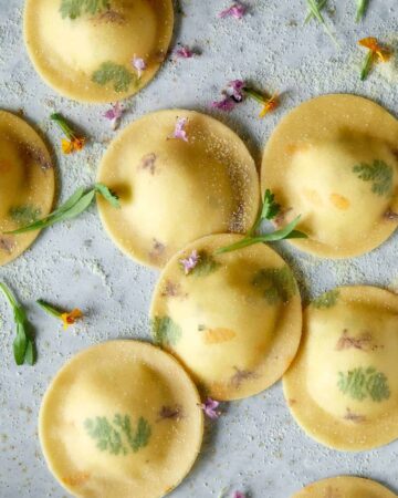 Uncooked floral laced ravioli with cheesy herb ricotta filling.
