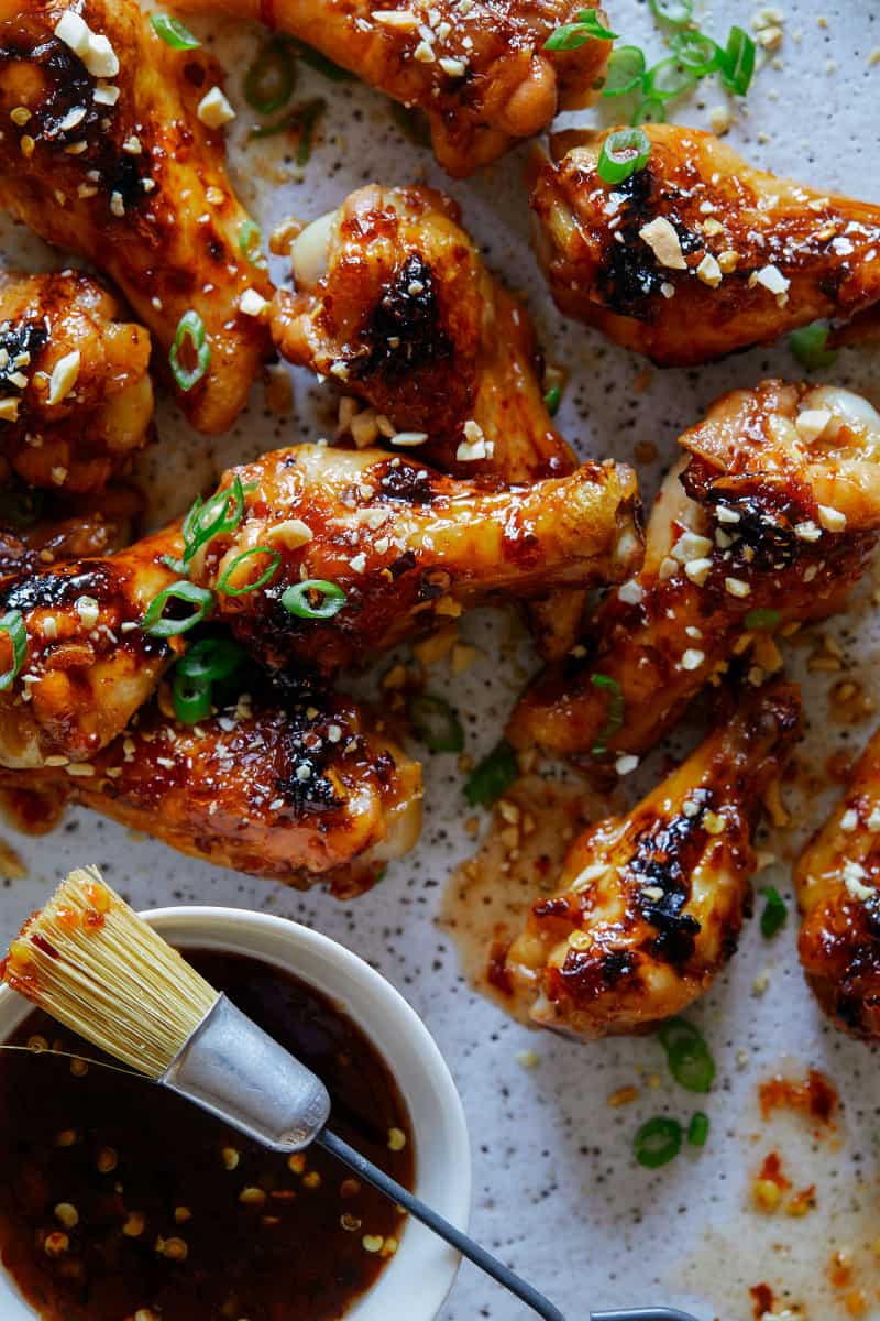 Sticky Honey Chicken Wings with peanuts and green onions. 