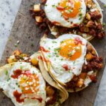 A close up of chorizo and fried egg breakfast tacos.